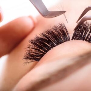 woman with tweezers putting in lash extensions